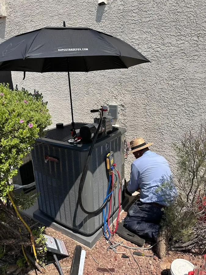 HVAC technician performing outdoor AC maintenance in Tigard