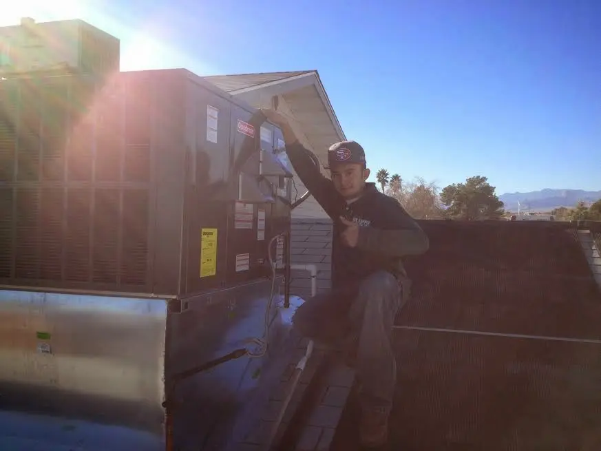 HVAC technician performing HVAC Inspection on a rooftop unit in Tigard